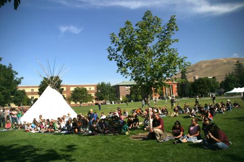 University of Montana community gathered near a teepee set up on campus